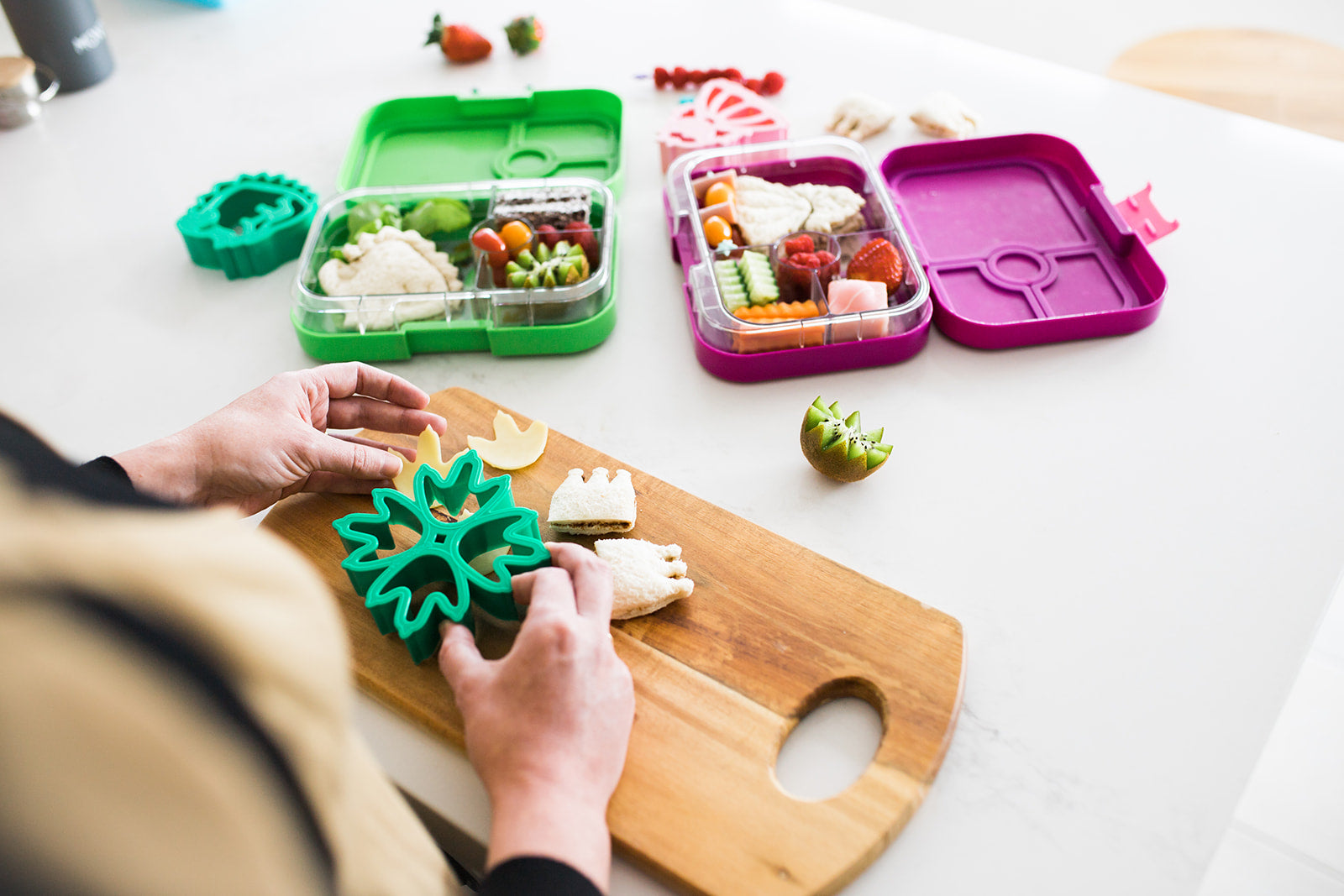 A mother making sandwiches using The Lunch Punch Sandwich cutters for her kids lunch boxes.